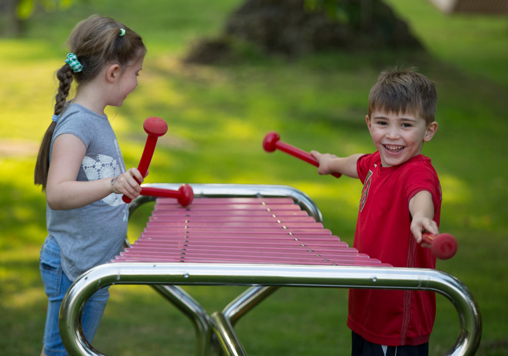 kids playing with an outdoor xylophone 